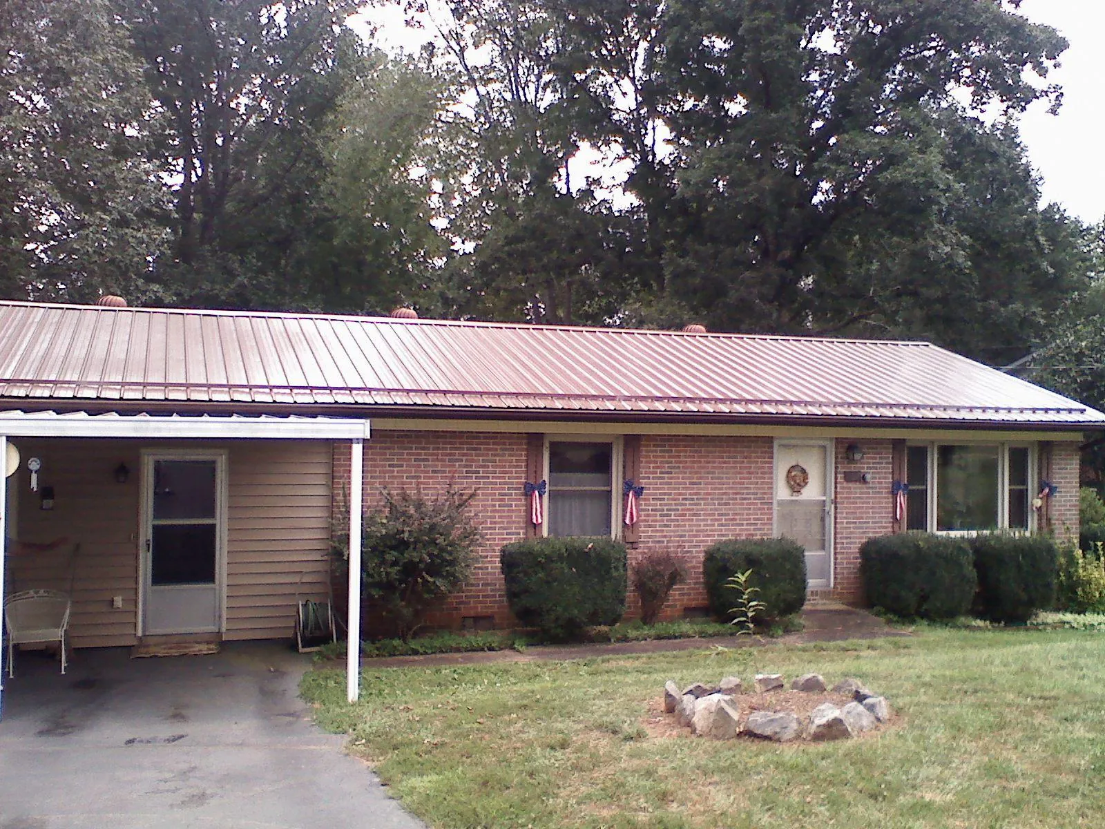 Bronze metal roof and carport on a brick ranch home — Roof Repair work by our crew in Waldo